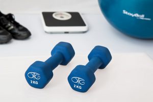 Pair of dumbbells, scale, workout shoes, and exercise ball