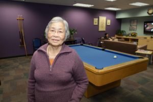 woman standing next to pool table
