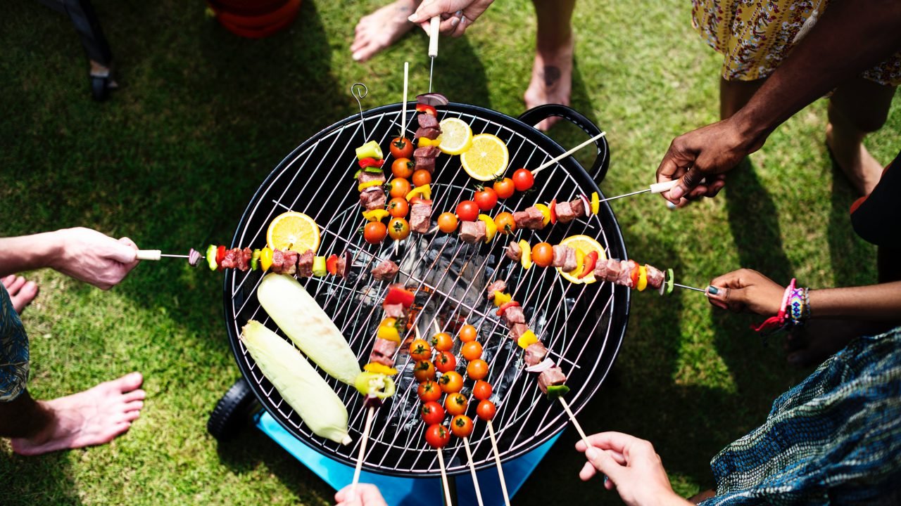 Group of people grilling veggies over a fire