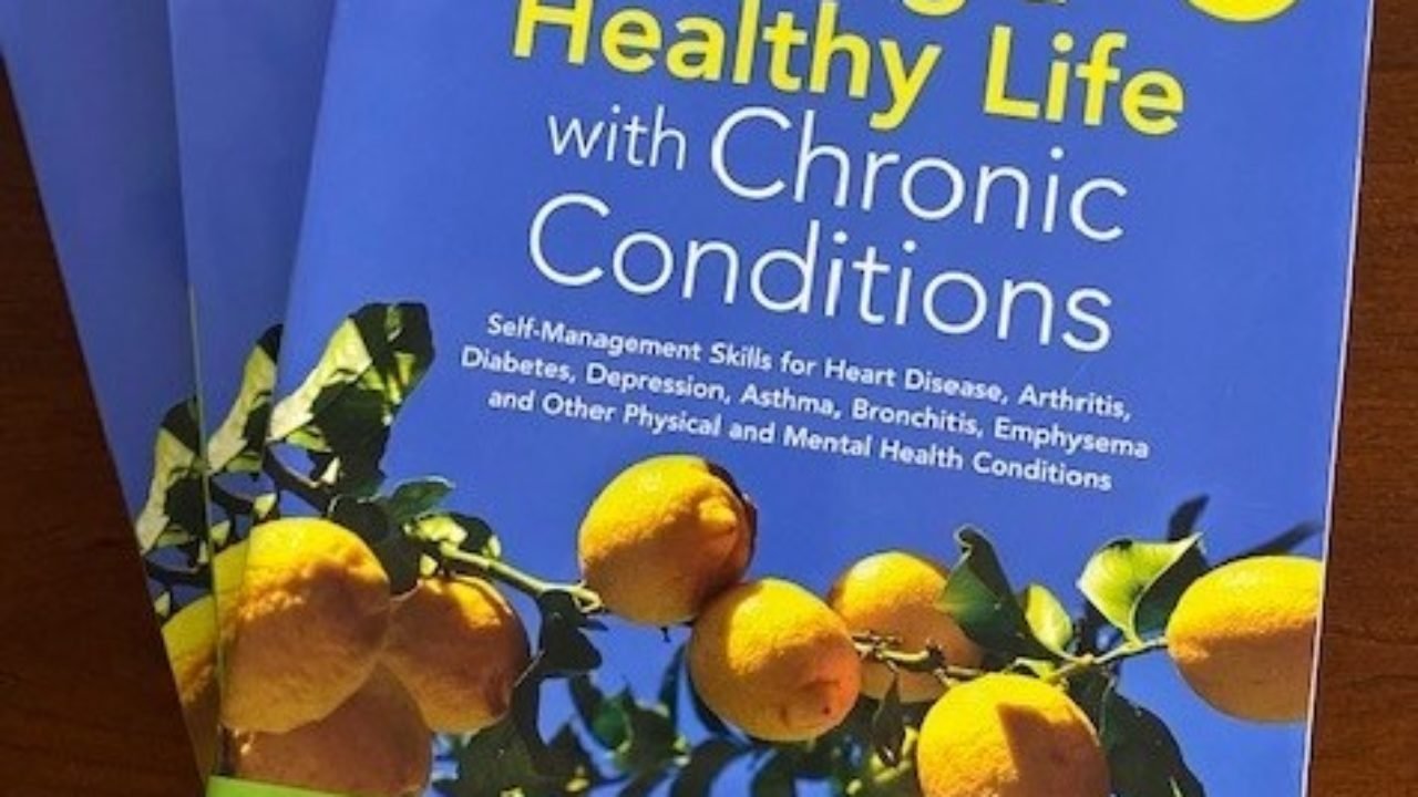 "Living a Health Live with Chronic Conditions" books piled on a table