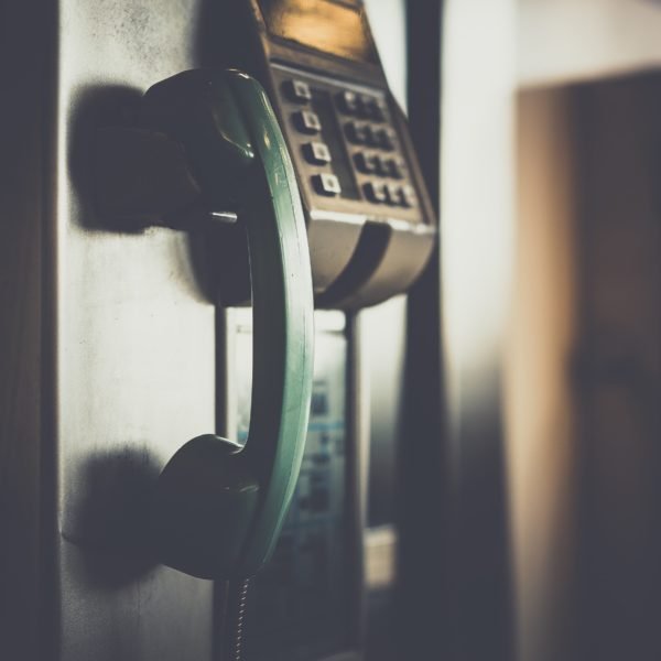 Pay telephone hanging next to payment system with keypad
